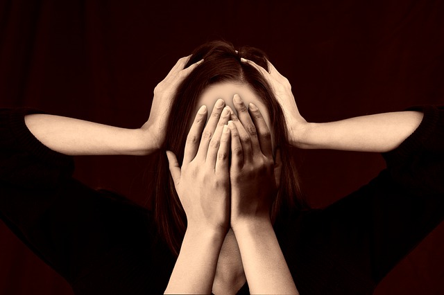 Girl with hands covering face and extra set on head, looking overwhelmed.