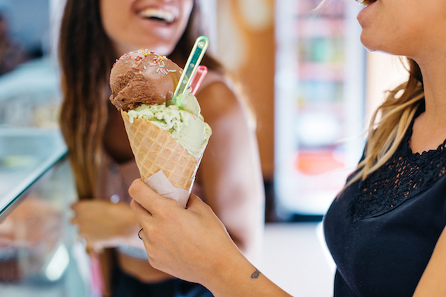 Two girls enjoying an ice cream cone.