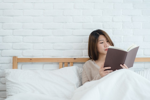 a woman reading in bed. 