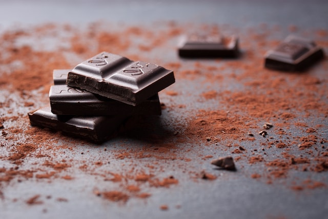 several bars of chocolate surrounded by cocoa powder.