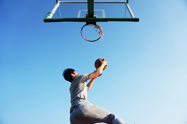 Man going up to shoot a basketball, one of the sports requiring lots of skills to help increase your esteem.