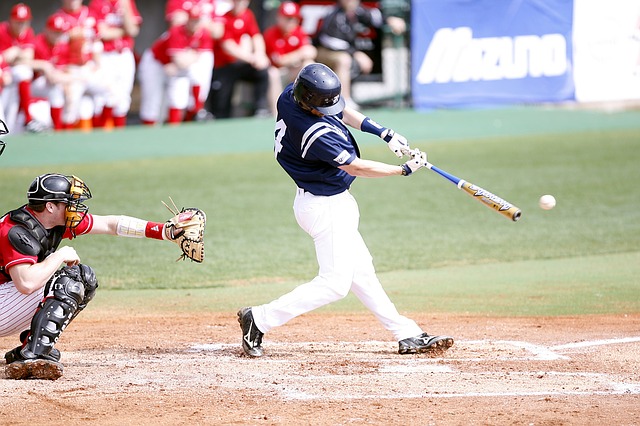 man playing baseball, batting and focused.