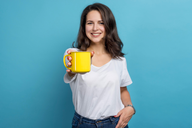 woman holding out a mug to the camera. 