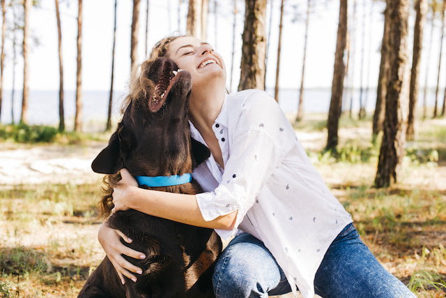 woman smiling hugging her rescue dog.