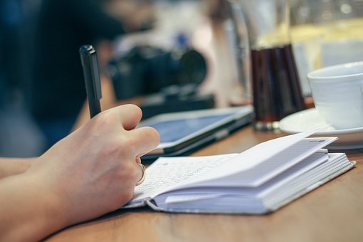 Persona escribiendo en una libreta.